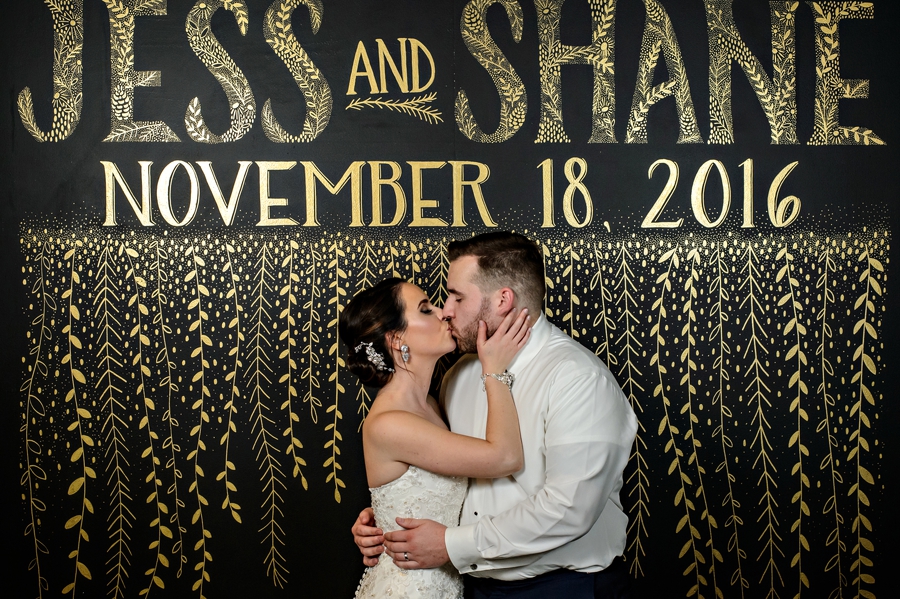 A married couple kiss in their photo booth.